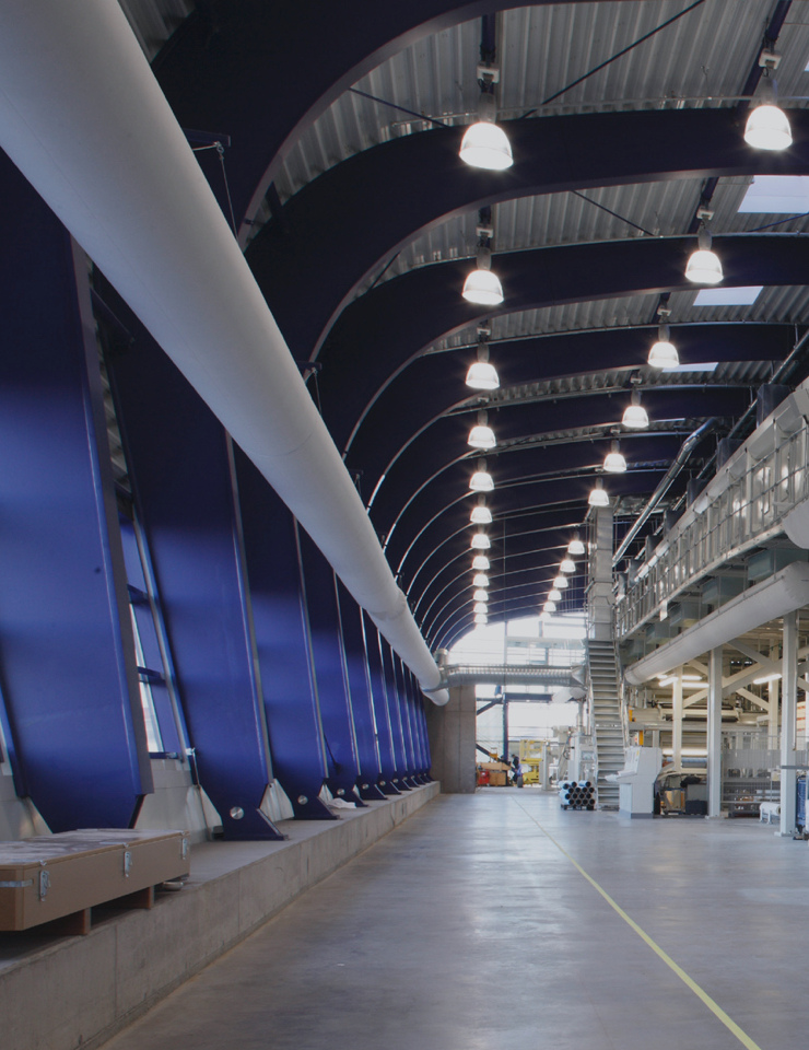 A modern interior with high, vaulted ceilings, blue walls, and evenly distributed ceiling lights.