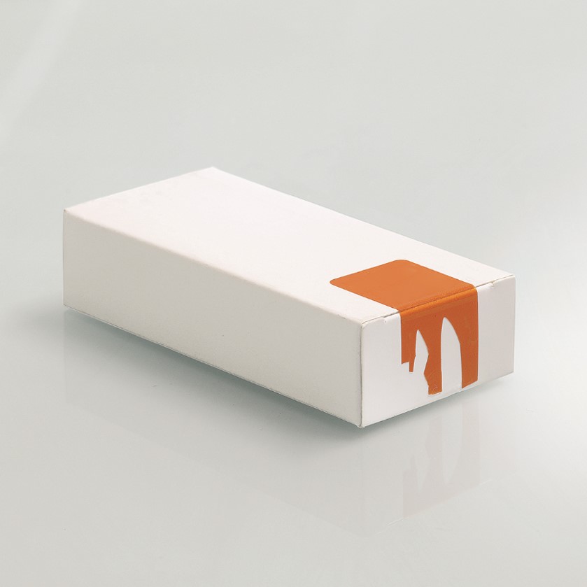 White folding box with an orange, damaged label on the side, placed on a smooth surface.