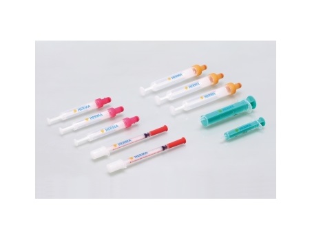 A arrangement of syringes in various colours and sizes, some with colored caps, against a neutral background.
