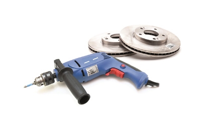 A blue drill lies next to two brake discs. The drill has a handle and a rotating tip for various applications.