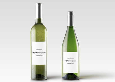 Two bottles of white wine with labels: one Chardonnay from 2016 and one Riesling from 2017, both named 'HERMAexquisite.
