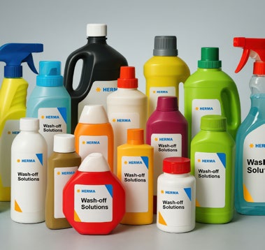 Various bottles and containers with cleaning agents, labelled 'Wash-off Solutions' and featuring the HERMA logo.